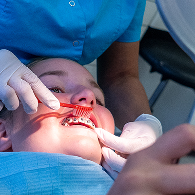 Orthodontist die de tanden poetst bij een kind
