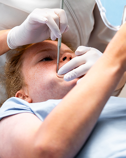 Orthodontist die de tanden poetst bij een kind